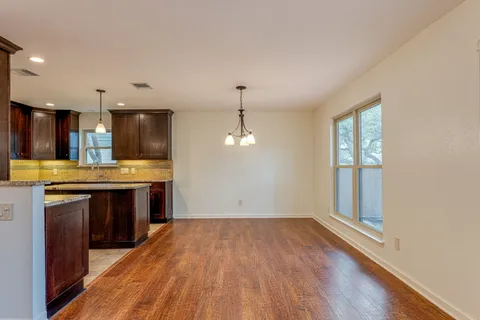a kitchen with kitchen island wooden floors appliances and cabinets