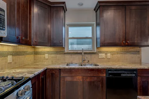 a kitchen with granite countertop cabinets and stainless steel appliances