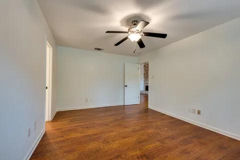 a view of an empty room with a chandelier fan