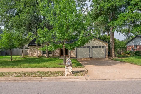 a front view of a house with a yard and trees