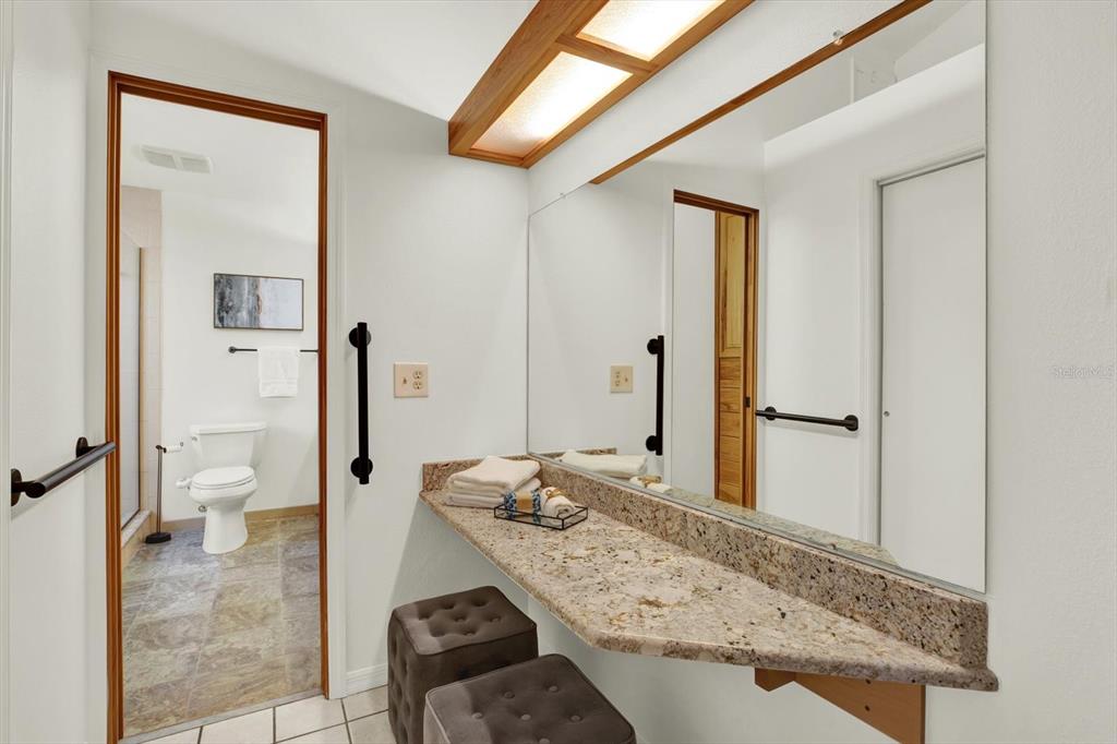 4684 West Huron Road St. Petersburg, FL 33708 - Photo 12 of 31 a bathroom with a granite countertop sink and a mirror