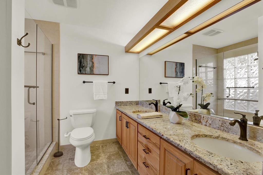 4684 West Huron Road St. Petersburg, FL 33708 - Photo 13 of 31 a spacious bathroom with a granite countertop sink toilet and shower