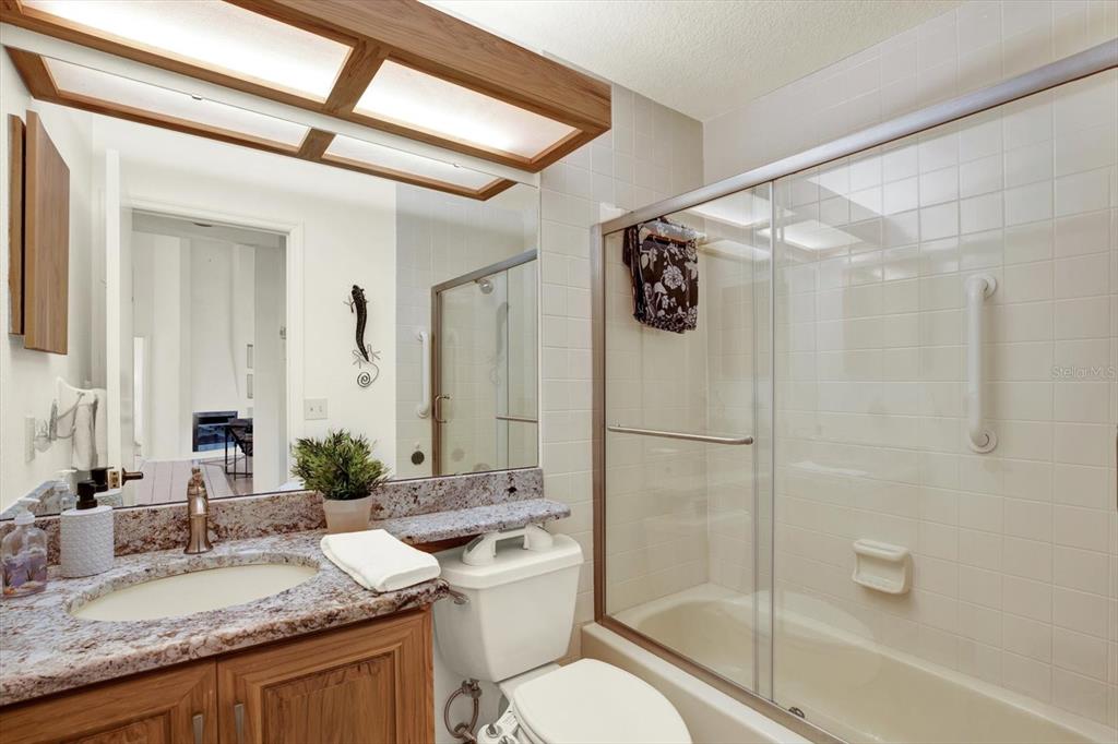 4684 West Huron Road St. Petersburg, FL 33708 - Photo 16 of 31 a bathroom with a granite countertop sink toilet and shower