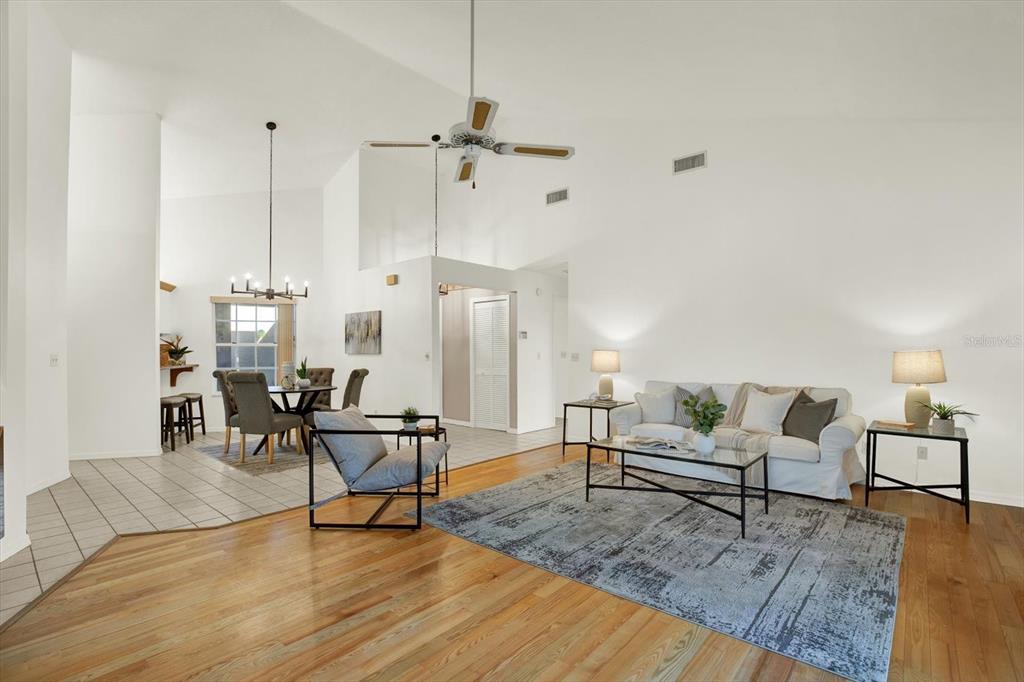 4684 West Huron Road St. Petersburg, FL 33708 - Photo 3 of 31 a living room with couches chairs and kitchen view with wooden floor