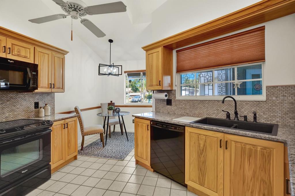 4684 West Huron Road St. Petersburg, FL 33708 - Photo 6 of 31 a kitchen with stainless steel appliances granite countertop a sink stove and cabinets