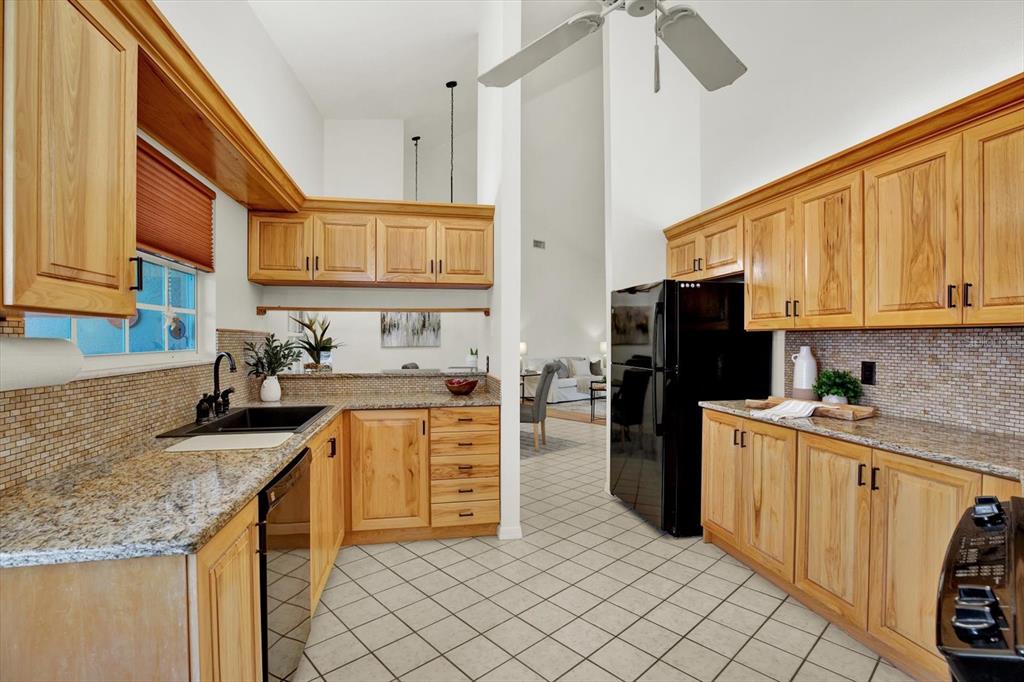 4684 West Huron Road St. Petersburg, FL 33708 - Photo 7 of 31 a kitchen with granite countertop a sink a counter top space stainless steel appliances and cabinets