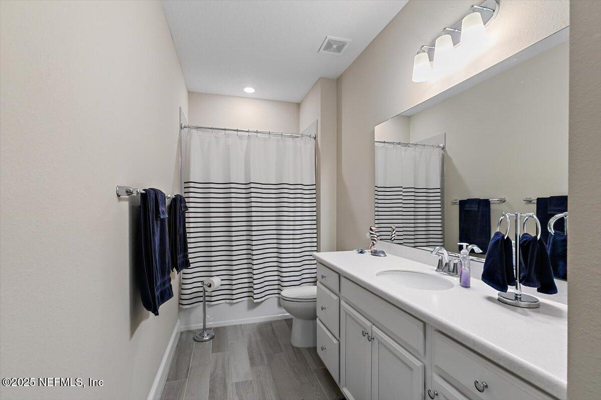 2661 Alexia Circle Jacksonville, FL 32246 - Photo 12 of 22 a bathroom with a double vanity sink toilet and mirror