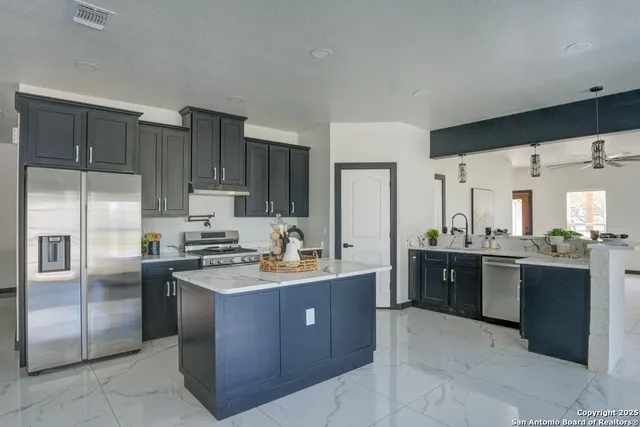 a kitchen with stainless steel appliances granite countertop a stove a sink dishwasher a refrigerator and a refrigerator