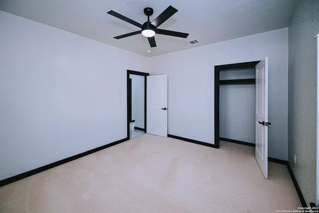 an empty room with a ceiling fan and a window