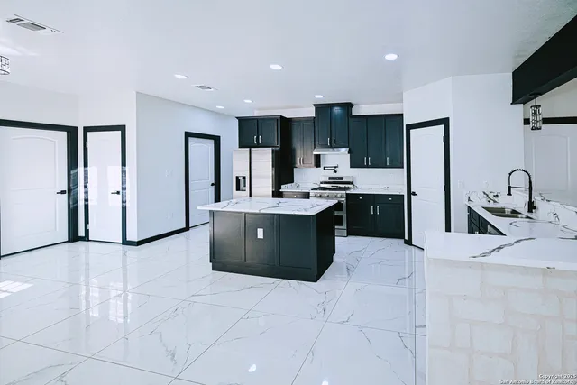a kitchen with stainless steel appliances kitchen island granite countertop a sink and cabinets