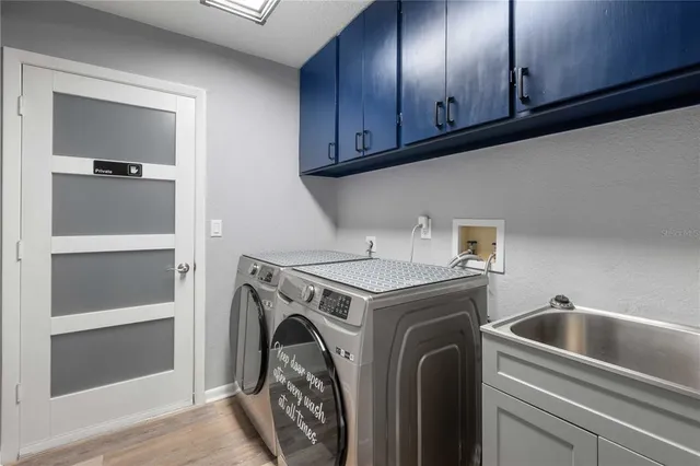 a utility room with sink dryer and washer