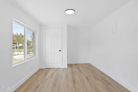 a view of a yard in front of a house with a large tree