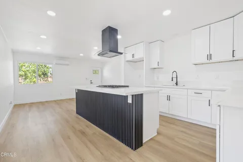 a kitchen with granite countertop white cabinets and stainless steel appliances