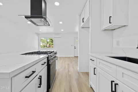 a view of a kitchen with a sink and dishwasher a refrigerator with wooden floor