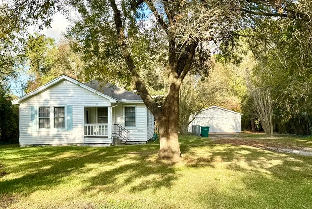 a front view of house with yard and trees around