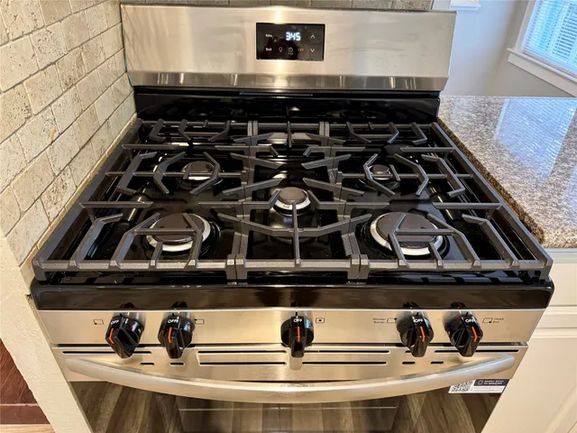 a close view of a stove a microwave and white cabinets
