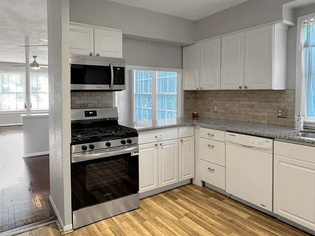 a kitchen with white cabinets stainless steel appliances and sink