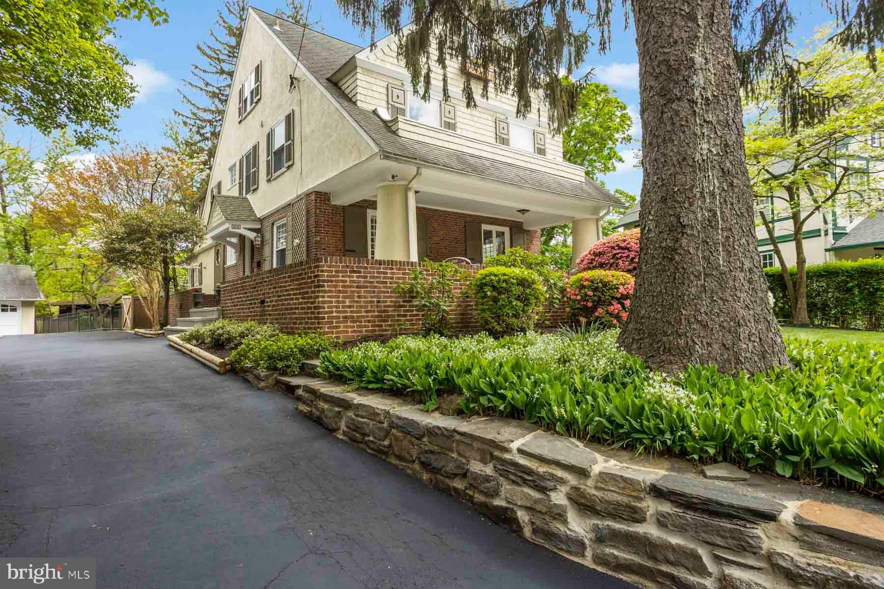 261 Forrest Road Merion Station, PA 19066 - Photo 36 of 43 a front view of a house with a yard and a garden