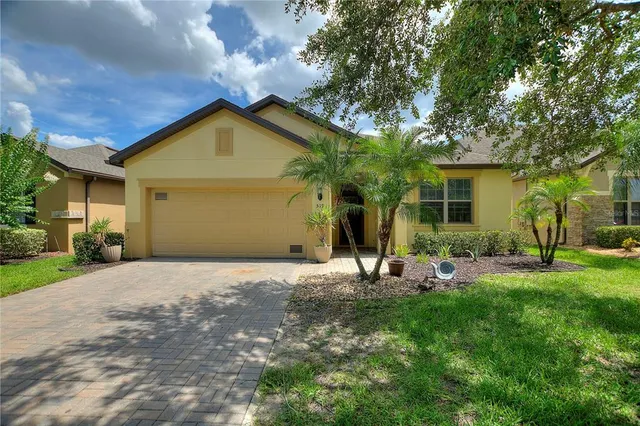 a backyard of a house with table and chairs and potted plants