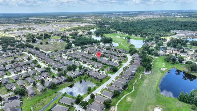 an aerial view of residential houses with outdoor space and trees