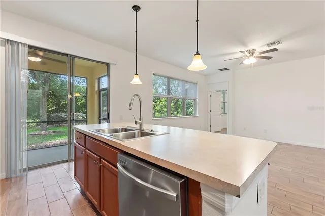 a kitchen with a stove a sink a center island and windows