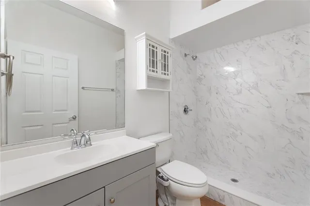 a bathroom with a sink a toilet and shower