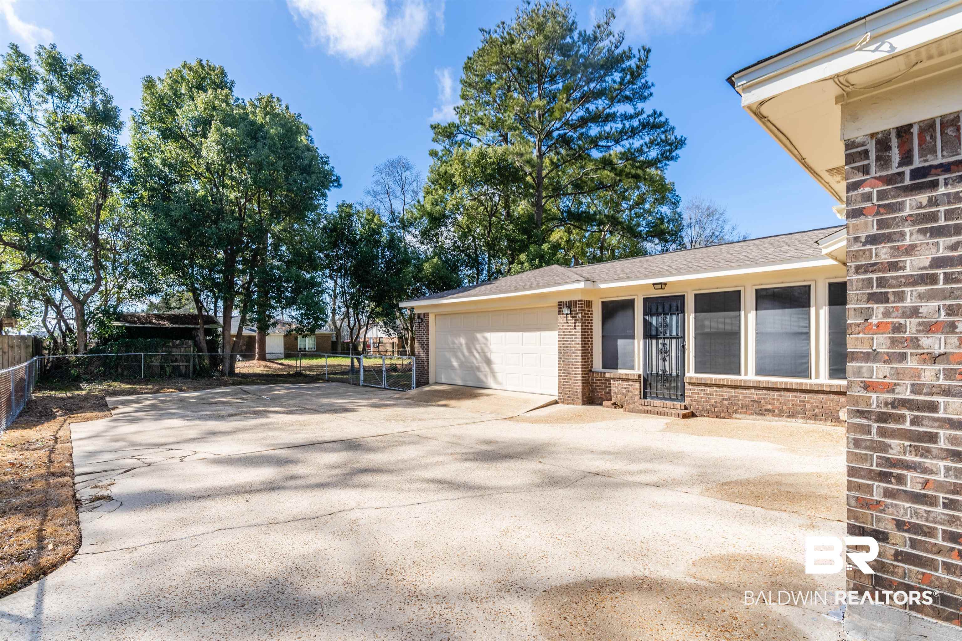 9751 Pine Knoll Road Mobile, AL 36608 - Photo 35 of 36 View of patio / terrace with driveway and a garage