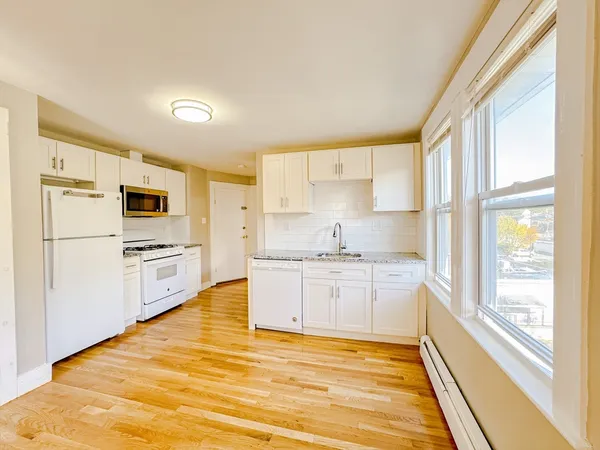 a kitchen with stainless steel appliances granite countertop a stove a sink and a refrigerator