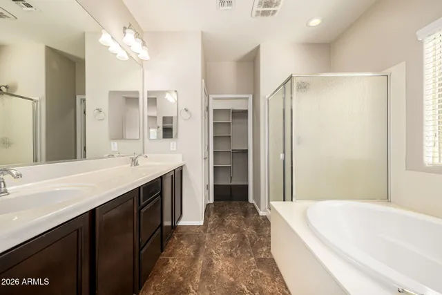 a spacious bathroom with a tub sink shower and mirror