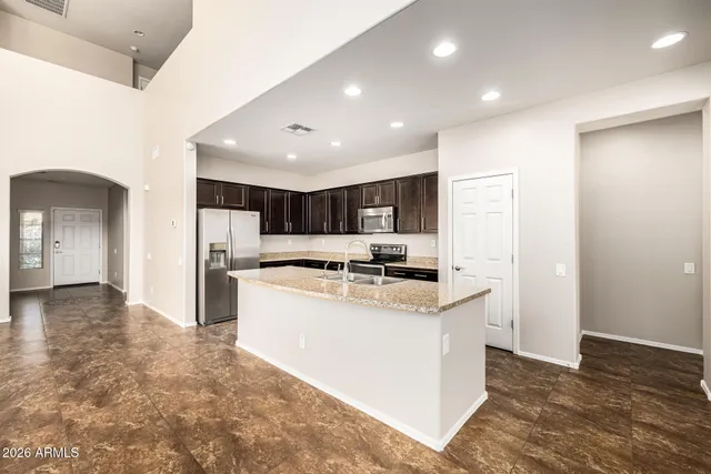 a kitchen with stainless steel appliances granite countertop sink stove and refrigerator