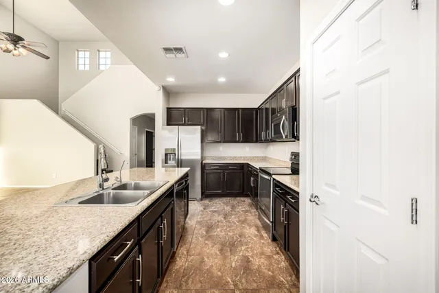 an empty room with a ceiling fan and carpet
