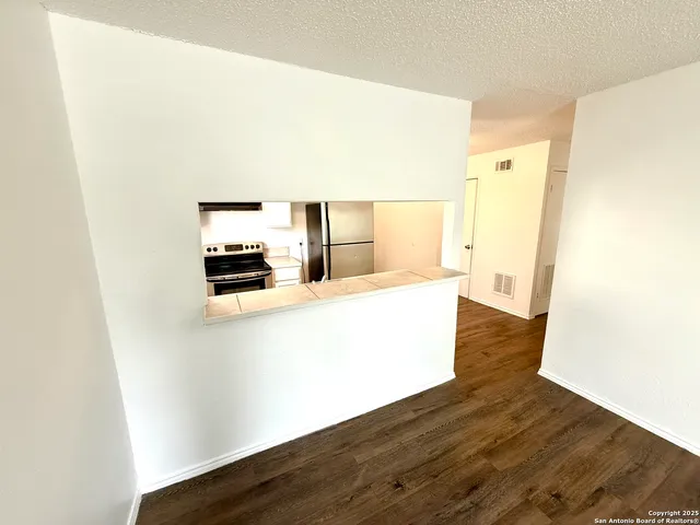 a kitchen with a refrigerator a stove and wooden floor