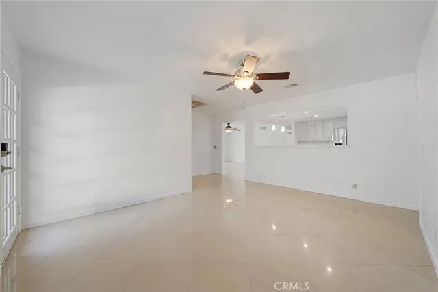 an empty room with windows and ceiling fan