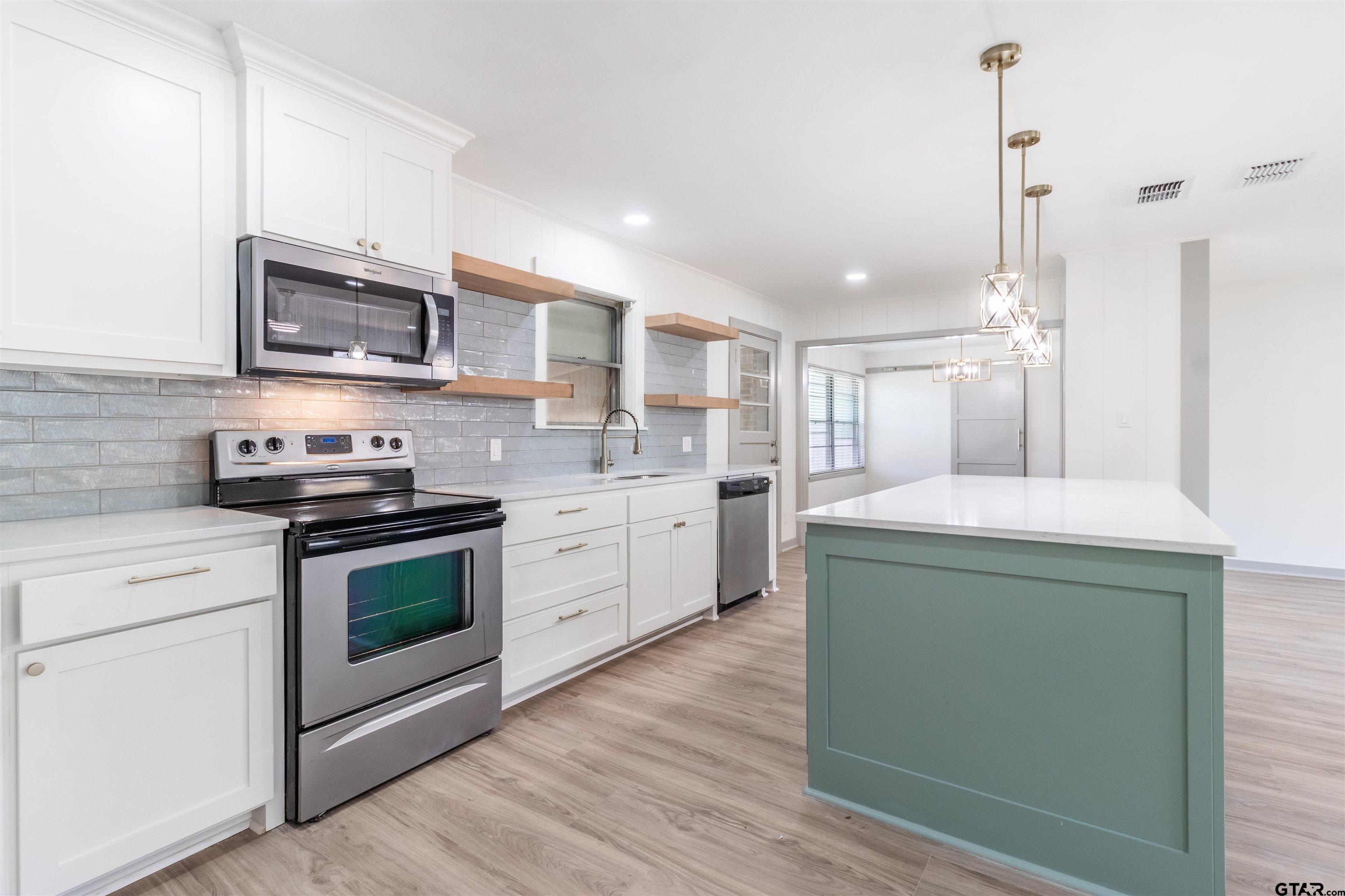 2419 Pounds Avenue Tyler, TX 75701 - Photo 12 of 48 a kitchen with stainless steel appliances granite countertop a stove a sink and a microwave