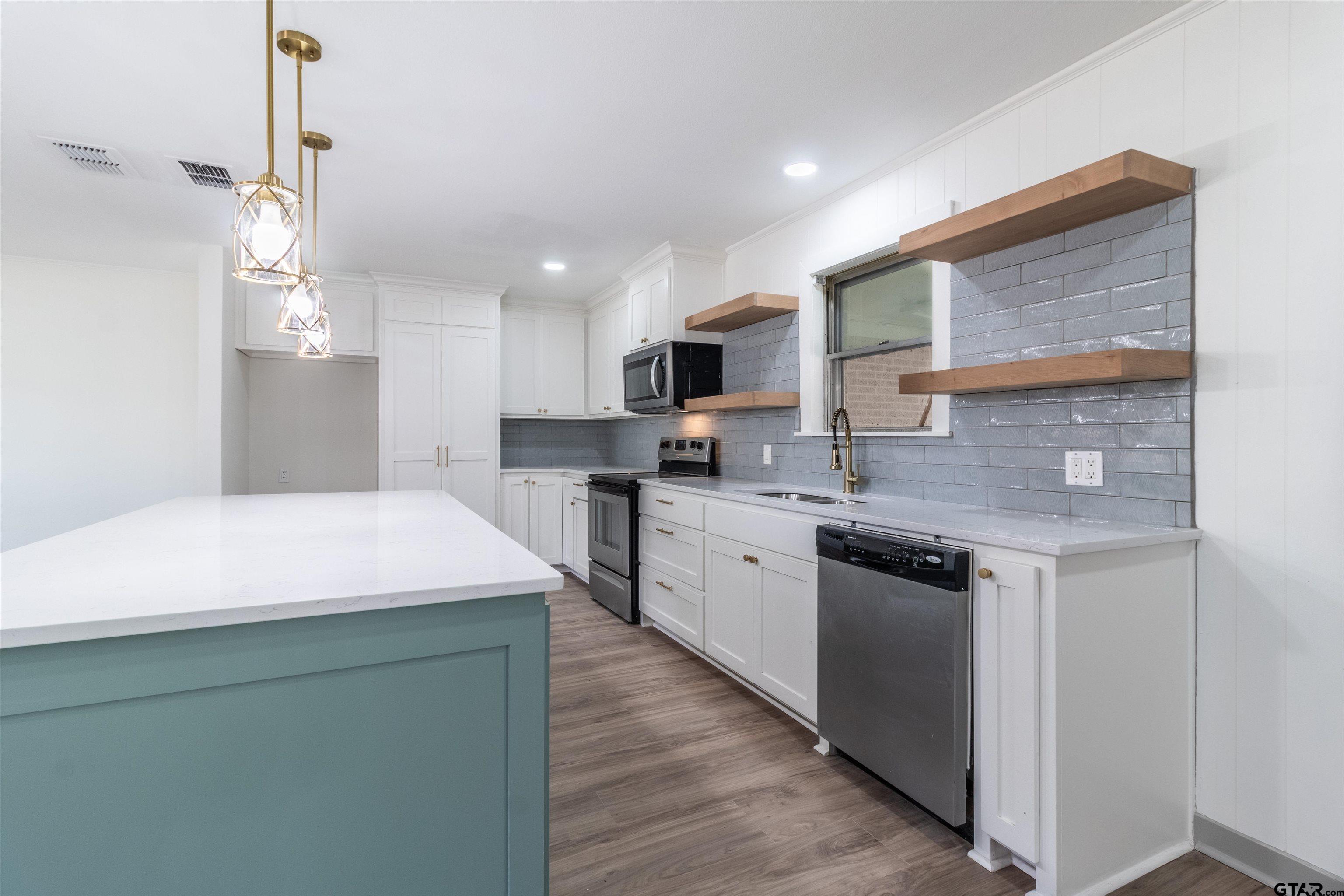 2419 Pounds Avenue Tyler, TX 75701 - Photo 13 of 48 a kitchen with kitchen island granite countertop a sink a counter top space stainless steel appliances and cabinets