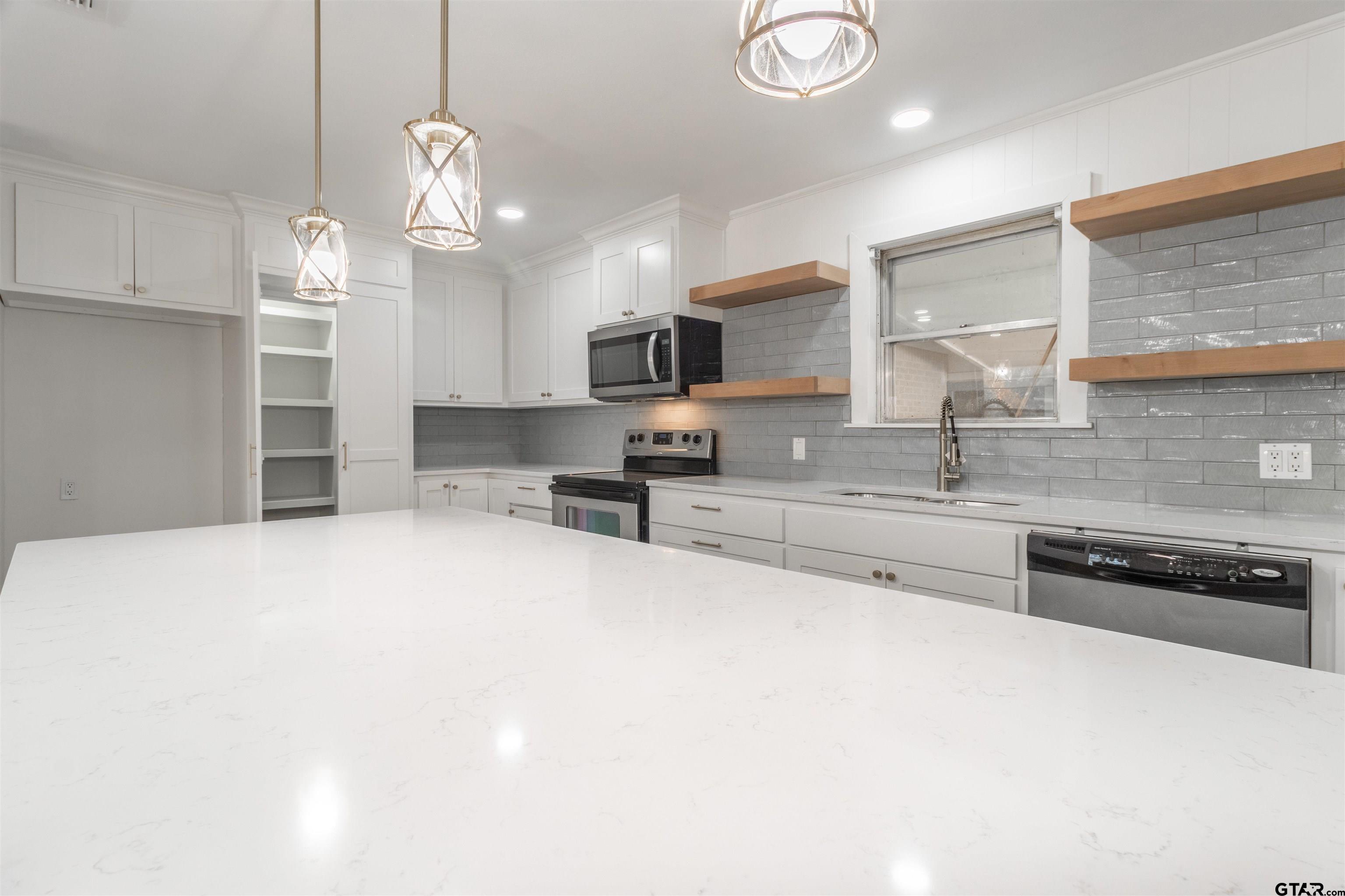 2419 Pounds Avenue Tyler, TX 75701 - Photo 14 of 48 a kitchen with stainless steel appliances granite countertop a stove and cabinets