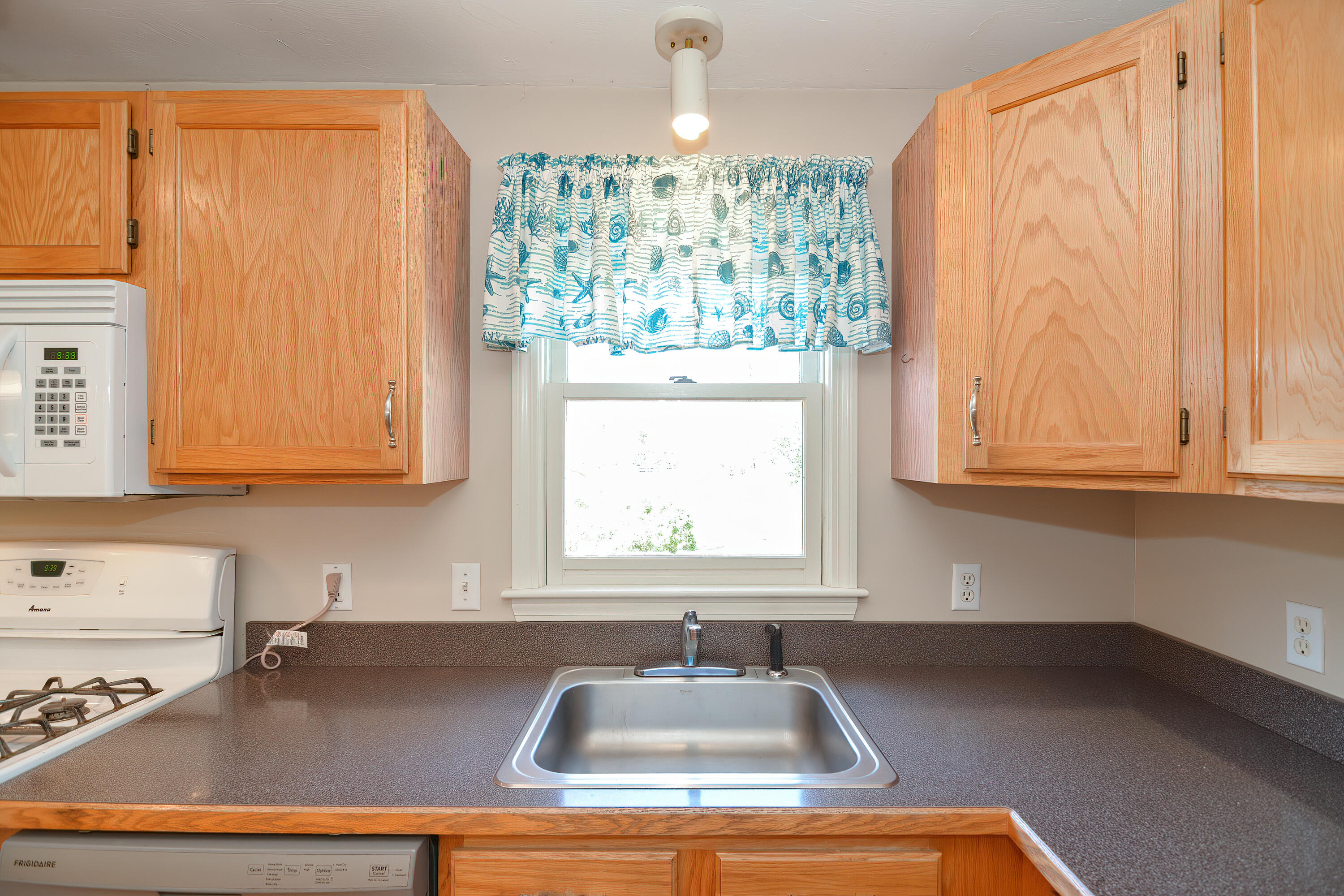 836 Cotuit Road Mashpee, MA 02649 - Photo 5 of 58 a kitchen with a sink window and cabinets