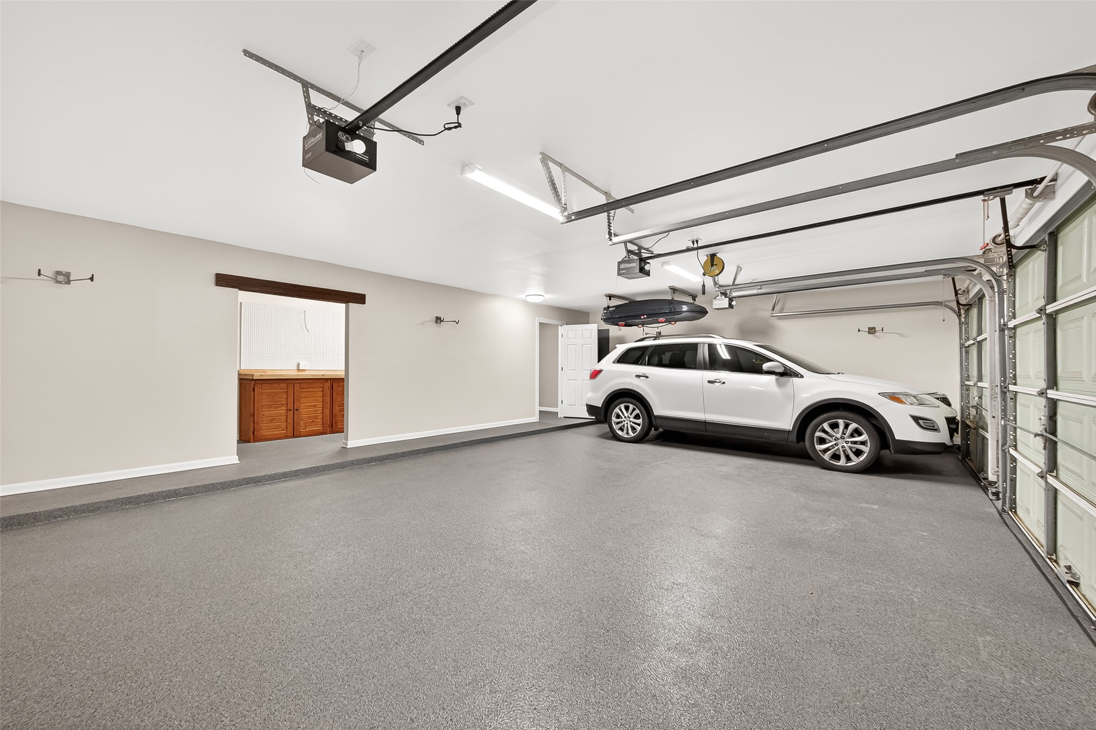 4203 Deforest Ridge Circle Katy, TX 77494 - Photo 47 of 50 This outstanding finished out, true 3 car garage with epoxy flooring provides ample storage for your vehicles and other toys. The garage comes with 4 bike racks and cargo box ceiling hoist (cargo box not included with the sale). Note that there is a storage room far right and workshop area in the center of this photo