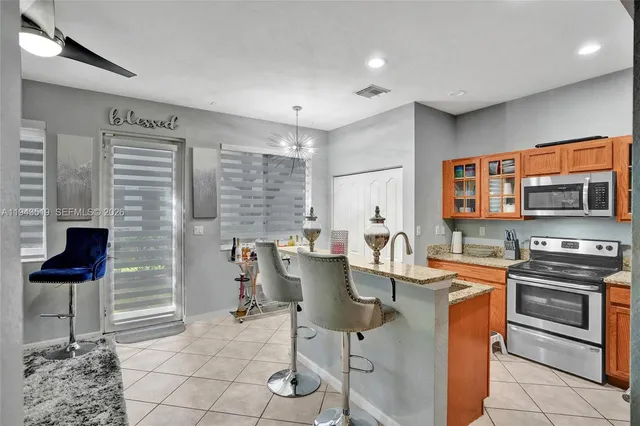 a kitchen with stainless steel appliances kitchen island granite countertop a stove a sink and a microwave