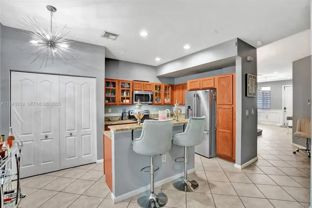 a kitchen with stainless steel appliances granite countertop a refrigerator and a stove top oven