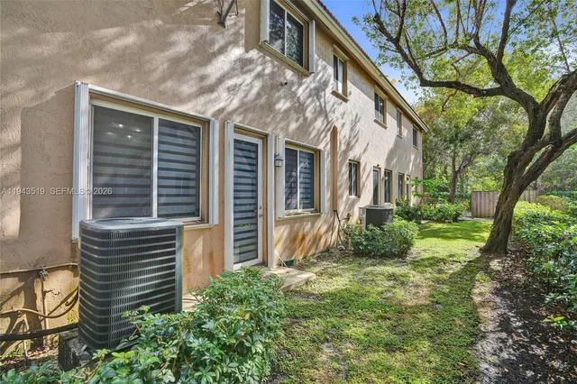 a view of a house with a yard and large tree