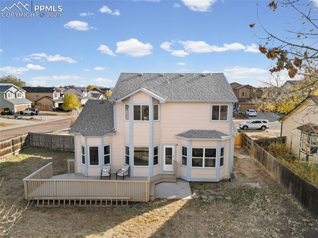 5428 Rondo Way Colorado Springs, CO 80911 - Photo 36 of 43 Rear view of house featuring roof with shingles, a wooden deck, a residential view, a fenced backyard, and a sunroom