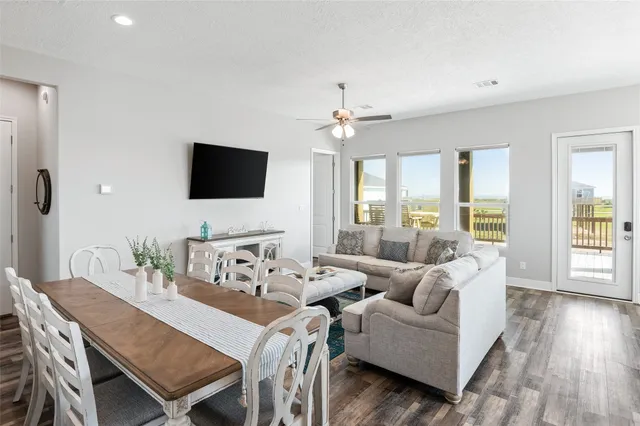 a living room with furniture a flat screen tv and a large window