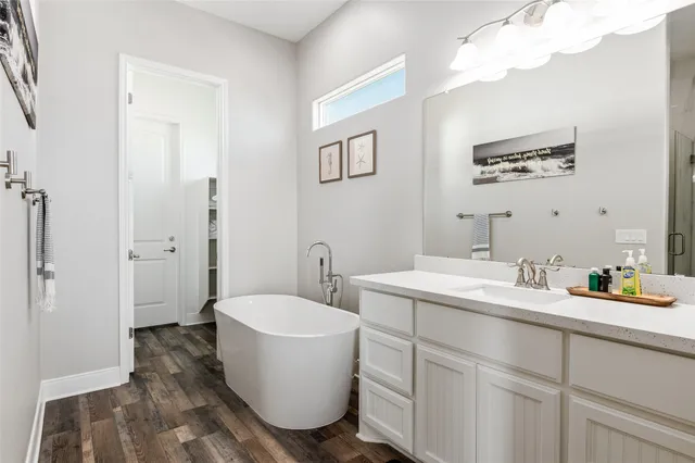 a bathroom with a double vanity sink mirror and bathtub