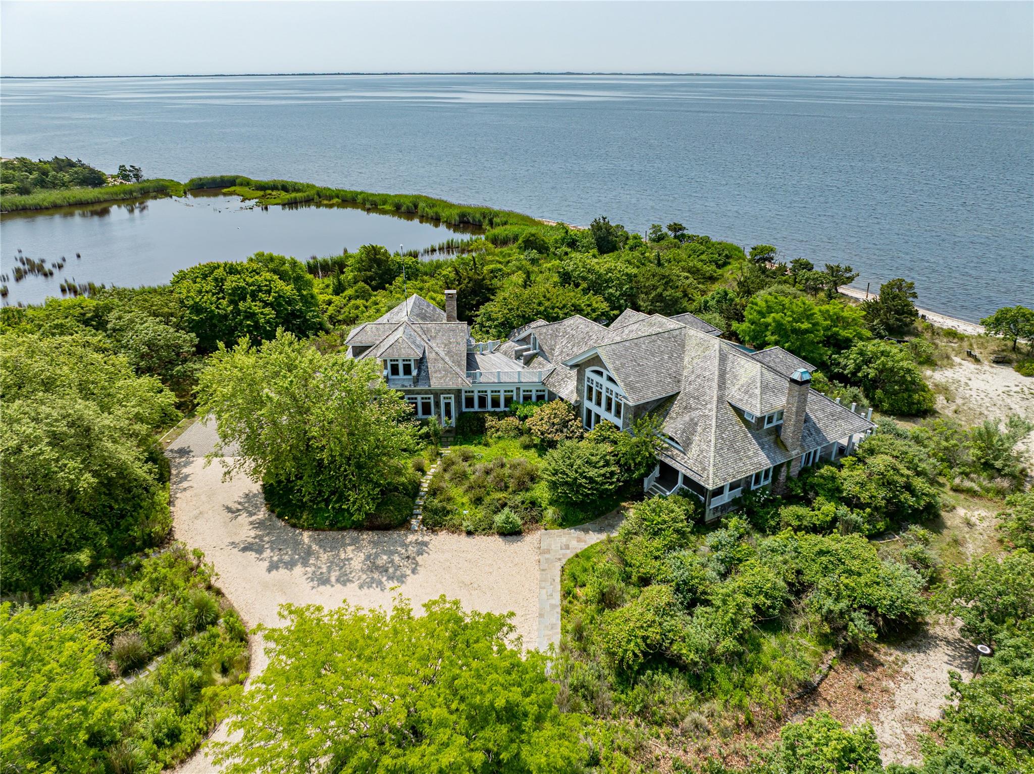 an aerial view of a house with a garden and lake view