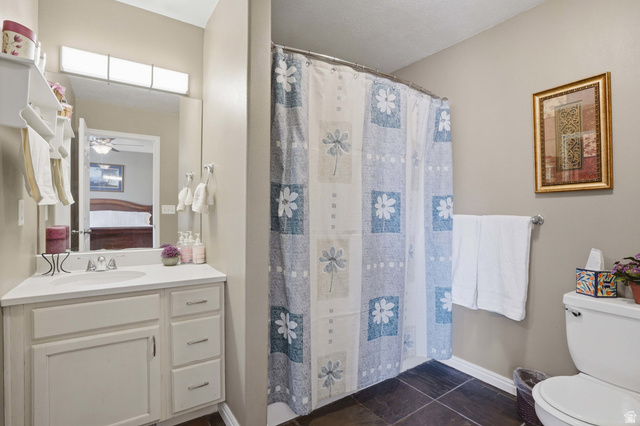 7737 Ranches Parkway Eagle Mountain, UT 84005 - Photo 12 of 28 Bathroom featuring a white single-sink vanity with a built-in countertop, a mirror, and overhead strip lighting