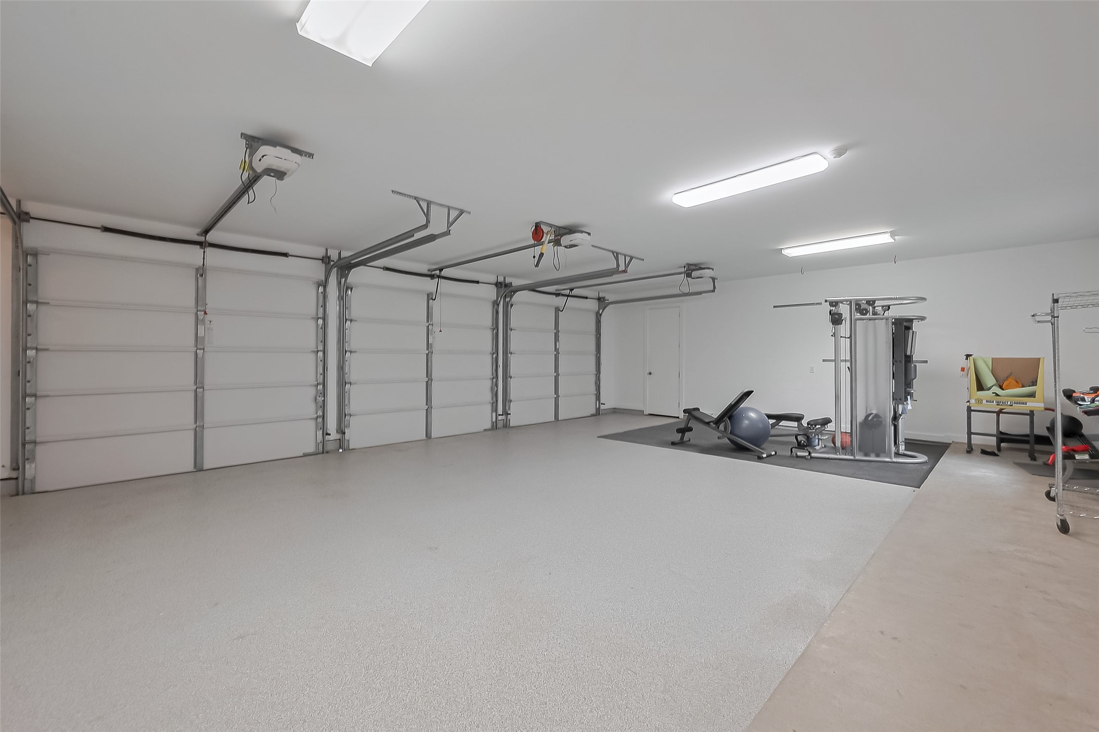 118 Angel Leaf Road The Woodlands, TX 77380 - Photo 40 of 50 Oversized garage with room for multiple vehicles, gym setup, and additional storage space.