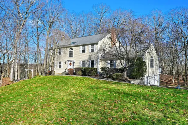 a view of a house with backyard and trees