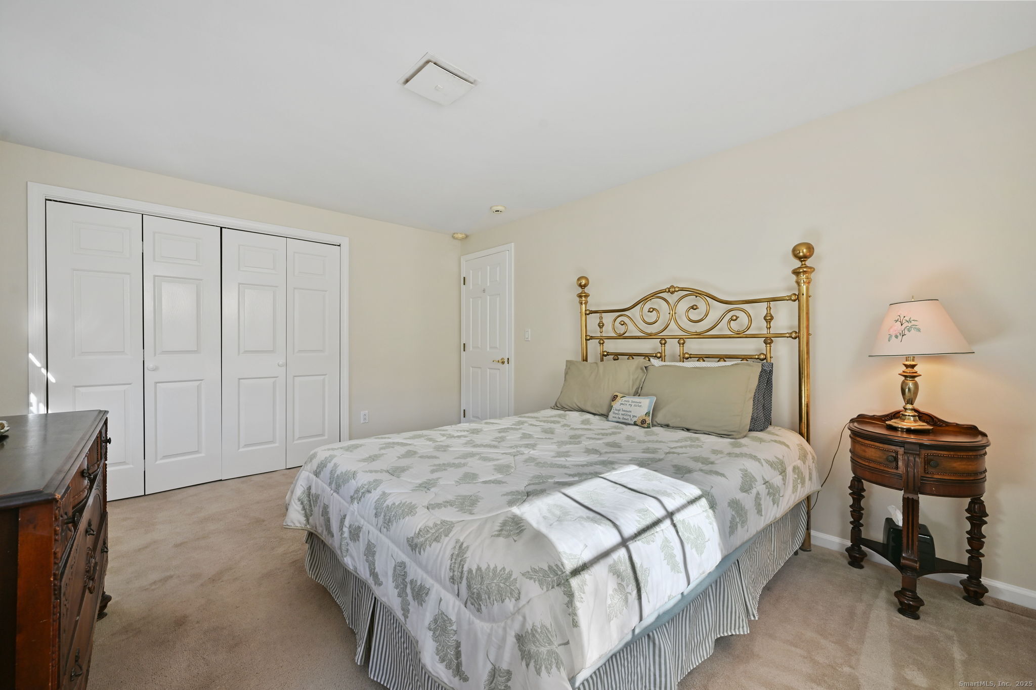 269 Thunder Lake Road Wilton, CT 06897 - Photo 17 of 26 a bedroom with a bed and a lamp on table