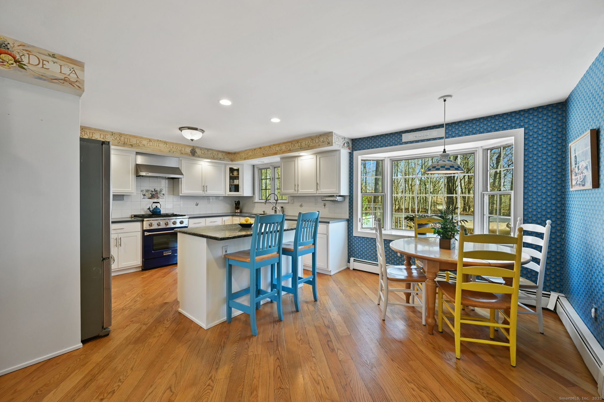269 Thunder Lake Road Wilton, CT 06897 - Photo 6 of 26 a kitchen with stainless steel appliances granite countertop a stove top oven a sink dishwasher a dining table and chairs with wooden floor